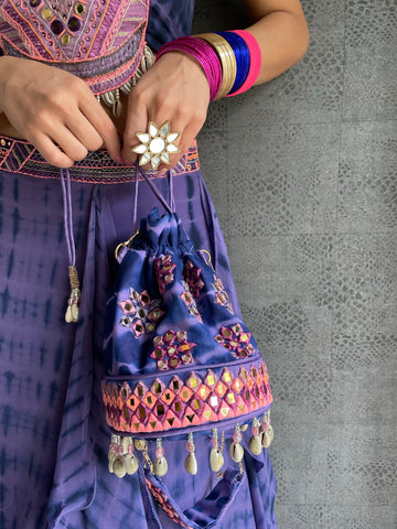 TALEISHA : Banjara cropped jacket, hand embroidered with mirrors, silk threads in tribal motifs with shell tassels. Paired along with our hand tied and dyed Handkerchief style lehenga and a versatile hot pink bandeau