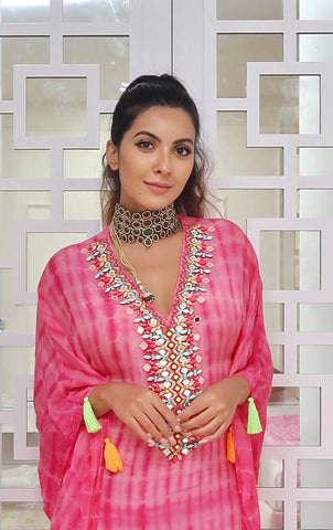 TALEISHA : Banjara cropped jacket, hand embroidered with mirrors, silk threads in tribal motifs with shell tassels. Paired along with our hand tied and dyed Handkerchief style lehenga and a versatile hot pink bandeau